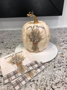 a white pumpkin sitting on top of a counter next to napkins and place mats