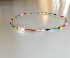 Rainbow and Pearl necklace/Beaded Rainbow Pearl necklace/Colourful Beaded chocker necklace/Colourful bead and pearl Add a bohochic vibe to your outfit with this colourful beaded chocker necklace. Layer it up with other necklaces for a rich bohemian look or wear it alone for a clean and chic style. SPECIFICATIONS Materials: * Seedbead rainbow mix and a freshwaterpearl in the front. * Goldfilled clasp and goldplated extenderchain. ❤Handmade with love by me in my jewelrystudio in Oslo, Norway. SIZE Handmade Multicolor Pearl Necklace For Summer, Bohemian Multicolor Pearl Necklace For Beach, Adjustable Multicolor Pearl Necklace For Summer, Festival Pearl Beaded Necklaces, Bohemian Pearl Beaded Necklaces With Tiny Beads, Multicolor Beaded Pearl Necklace For Summer, Multicolor Pearl Necklace With Colorful Beads For Summer, Summer Multicolor Beaded Pearl Necklace, Handmade Bohemian Pearl Necklace For Summer