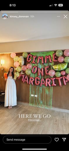 a woman standing in front of a wall with balloons