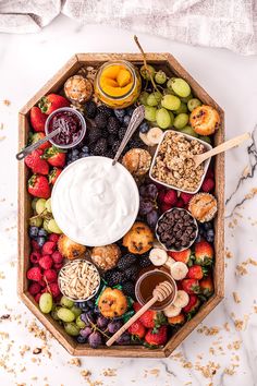 a platter filled with fruit, nuts and yogurt