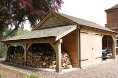 a car is parked in front of a shed with wood stacked up inside and out