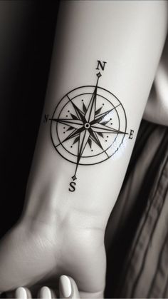 a person with a compass tattoo on their arm