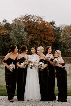 Bridesmaids wear long black velvet bridesmaid dresses with off-the-shoulder styling Black Velvet Bridesmaid Dresses Winter, Black Velvet Bridesmaid Dresses Long, Black Bridesmaid Dresses Velvet, Velvet Black Bridesmaid Dresses, Winter Black Bridesmaid Dresses, Black Velvet Bridesmaids, Black Bridesmaid Dresses Winter, Black Velvet Bridesmaid Dresses, Dark Bridesmaid Dresses