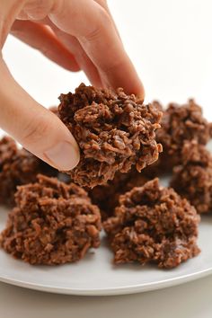 a person is picking up some cookies from a plate