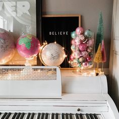 a white piano sitting in front of a christmas tree with ornaments on top of it