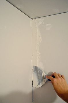 a person using a brush to paint the wall