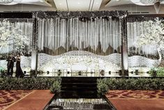 a man and woman standing in front of a stage set up for a wedding ceremony