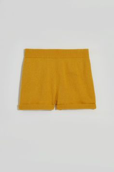 Hello, Jasper. Our comfy knitted shorts. These fun shorts are lightweight and cozy, with a rolled hem that includes an added link stitch detail. Easy and stylish, Jasper comes with a practical elasticated waistband and sports two handy side pockets. Jasper is composed of 100% recycled fibers, and is GRS certified. Both the fibers and the manufacturing are made in ITALY to lower our carbon footprint. Unisex. Carbon Footprint, Rolled Hem, Knit Shorts, Yellow, Knitting