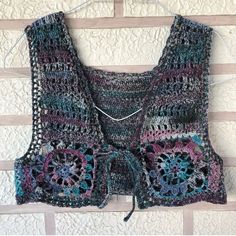 a crocheted vest hanging on a wall