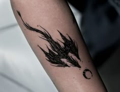 a tattoo on the arm of a person with a bird and moon in the background