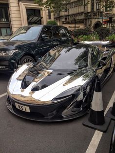 a black and white sports car parked next to other cars