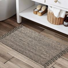 a bathroom with wooden floors and white furniture