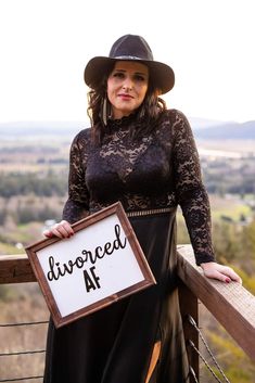 a woman in a dress and hat holding a sign that says, divored at