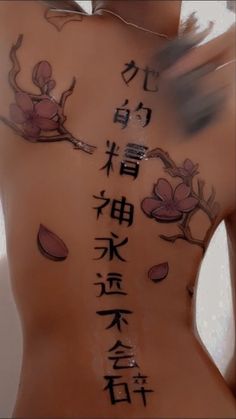 the back of a woman's body with chinese writing and flowers painted on it