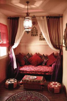 the interior of a room with red and white decor, including a couch, bed, window, and rug