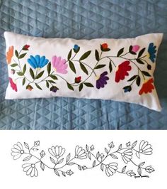 an embroidered pillow with flowers and leaves on it, next to a drawing of a flower