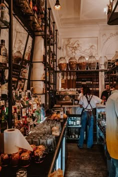 a man standing in front of a counter filled with food and drinks on it's shelves