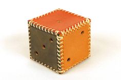 an orange and black square shaped object with holes in it's center on a white surface