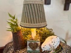 a lamp that is sitting on top of a table next to some potted plants