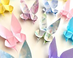 several origami butterflies sitting on top of a white table next to each other