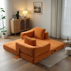 an orange couch sitting on top of a hard wood floor