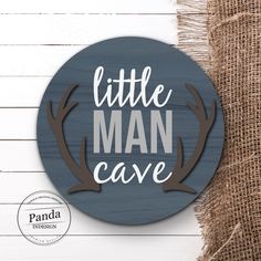 a wooden sign that says little man cave on the side of a white wood wall