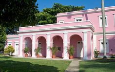 a pink house with white trim and columns