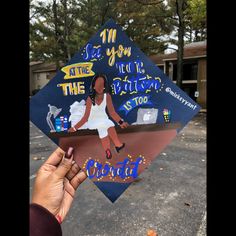 someone is holding up a graduation cap that has an image of a woman on it