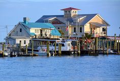 several boats are docked in the water next to houses on stilts and piers