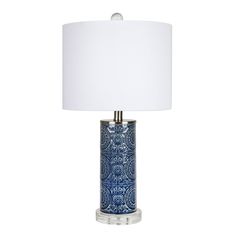 a blue and white table lamp with a white shade on the top, against a white background