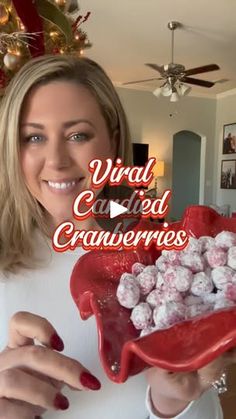 a woman holding a red bowl filled with candy