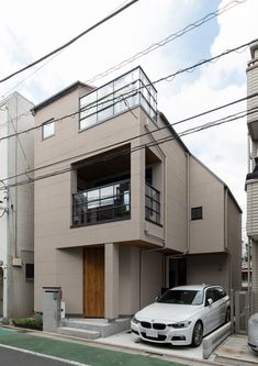 a white car parked in front of a building on the side of a road with power lines above it