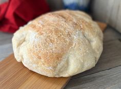 a loaf of bread sitting on top of a wooden cutting board