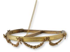 an ornately decorated gold metal object with chains hanging from it's sides