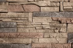 a stone wall that has been made with different types of stones and is brown in color