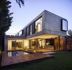 a modern house with a swimming pool in the middle of it's back yard