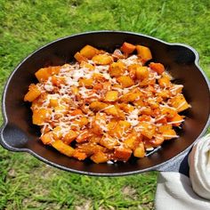 a pan filled with food sitting on top of a green field