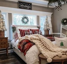 a bedroom decorated for christmas with red and white decor on the walls, windows, and bedding