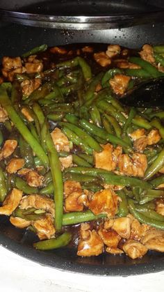 chicken and green beans cooking in a wok