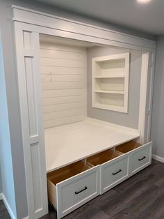 an empty closet with drawers and shelves in the middle, on top of a hard wood floor