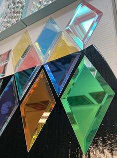 a multicolored glass sculpture hanging from the side of a building