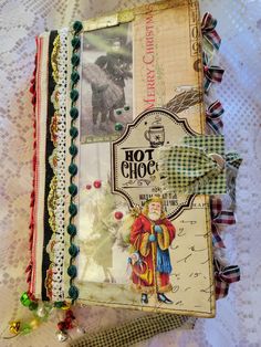 an old book is covered with vintage fabric and other decorative items, such as beads