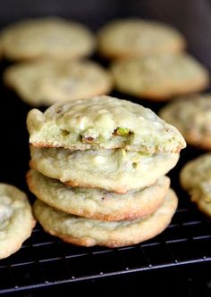 a stack of cookies sitting on top of a cooling rack with pistachios