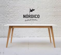 a white table sitting in front of a brick wall with the word nordico on it