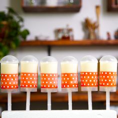 four candy lollipops with polka dots on them sitting in front of a table