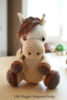 a crocheted stuffed horse sitting on top of a table