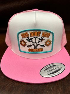 Red Dirt Hat Co. white and pink flat bill style snapback featuring the exclusive Buffalo Skull patch. Red Dirt Hat Co. is a brand for everyone. White Front Pink Mesh Back 5 Panel Red Dirt Buffalo Skull Patch Adjustable Snapback Flat Bill Buffalo Skull, Skull Patch, Flat Bill Hats, Snap Back Hat, Red Dirt, Red Panels, Western Store, Pink Flats, Cowgirl Western