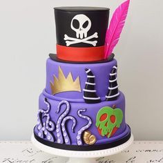 a three tiered cake decorated with purple and black frosting, topped with a top hat