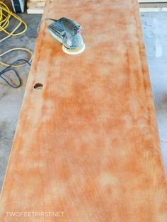 an electric sander is on top of a wooden table that's being worked on