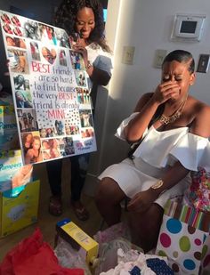 a woman sitting in front of a poster with pictures on it and another person standing next to her